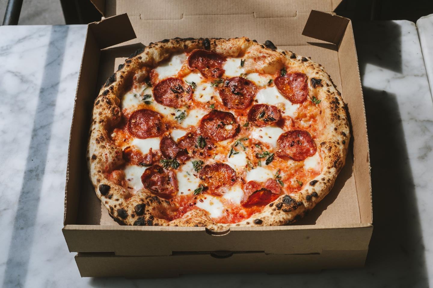 The restaurant features signature pizzas cooked in a traditional oven